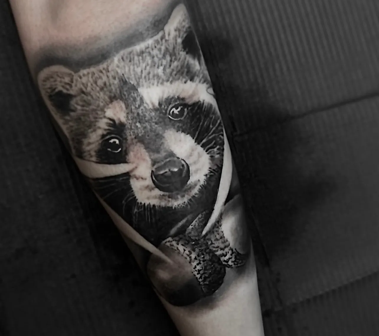 Black and grey realism raccoon forearm tattoo by Bishop Kelly