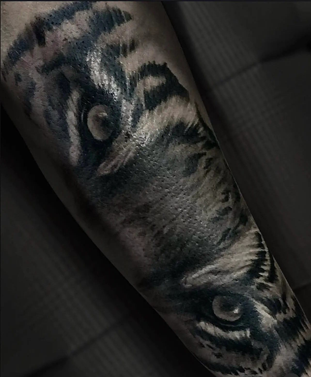 Black and grey realism tiger eyes forearm tattoo by Bishop Kelly