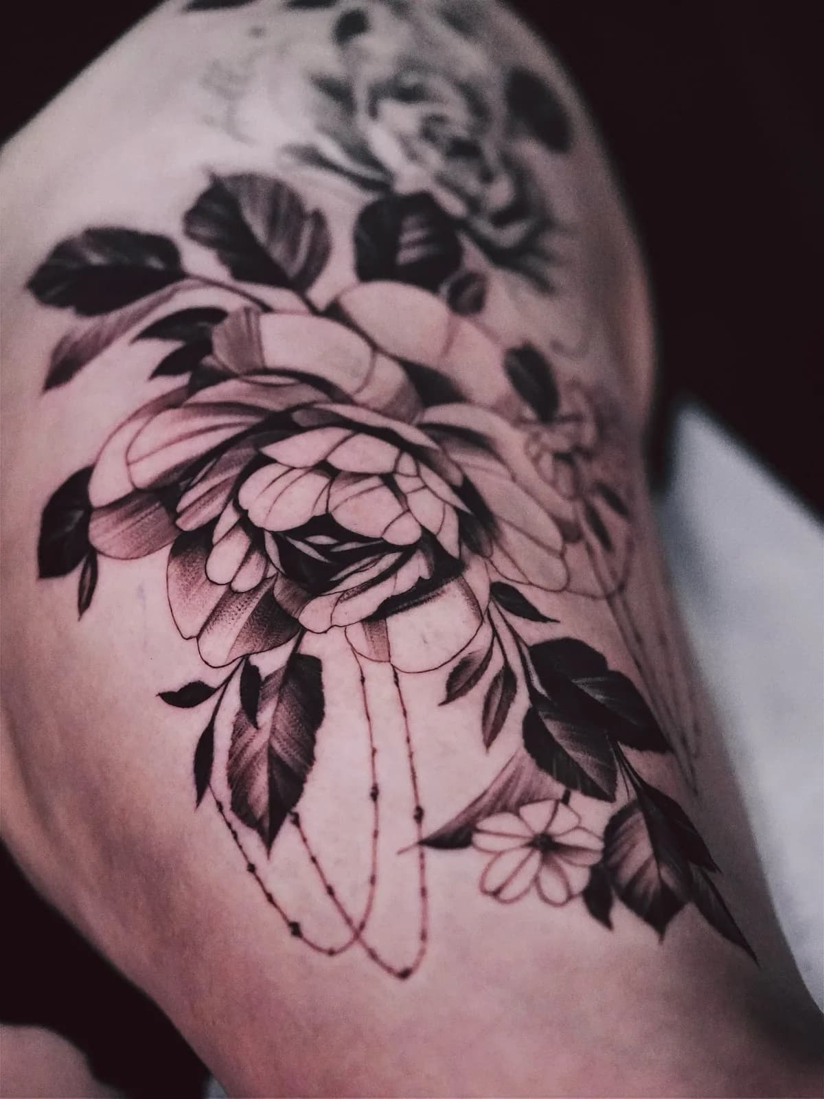 Black and grey floral thigh tattoo by Courtnie Heller