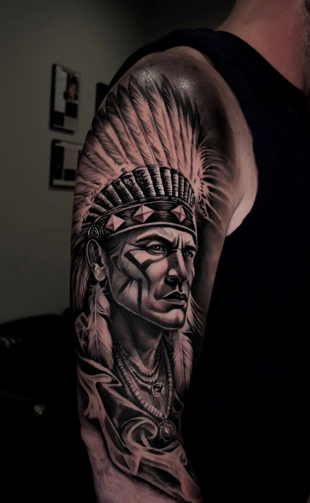 Black and grey Native American chief headdress arm tattoo by Joel Ponce