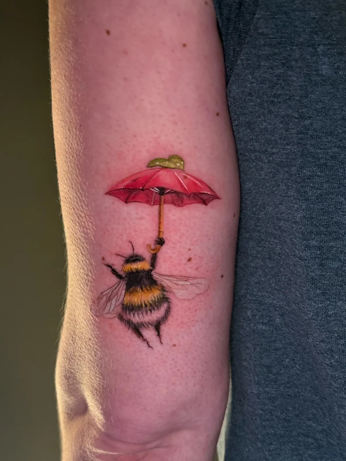 Color bumblebee with red umbrella forearm tattoo by Keisha Vo