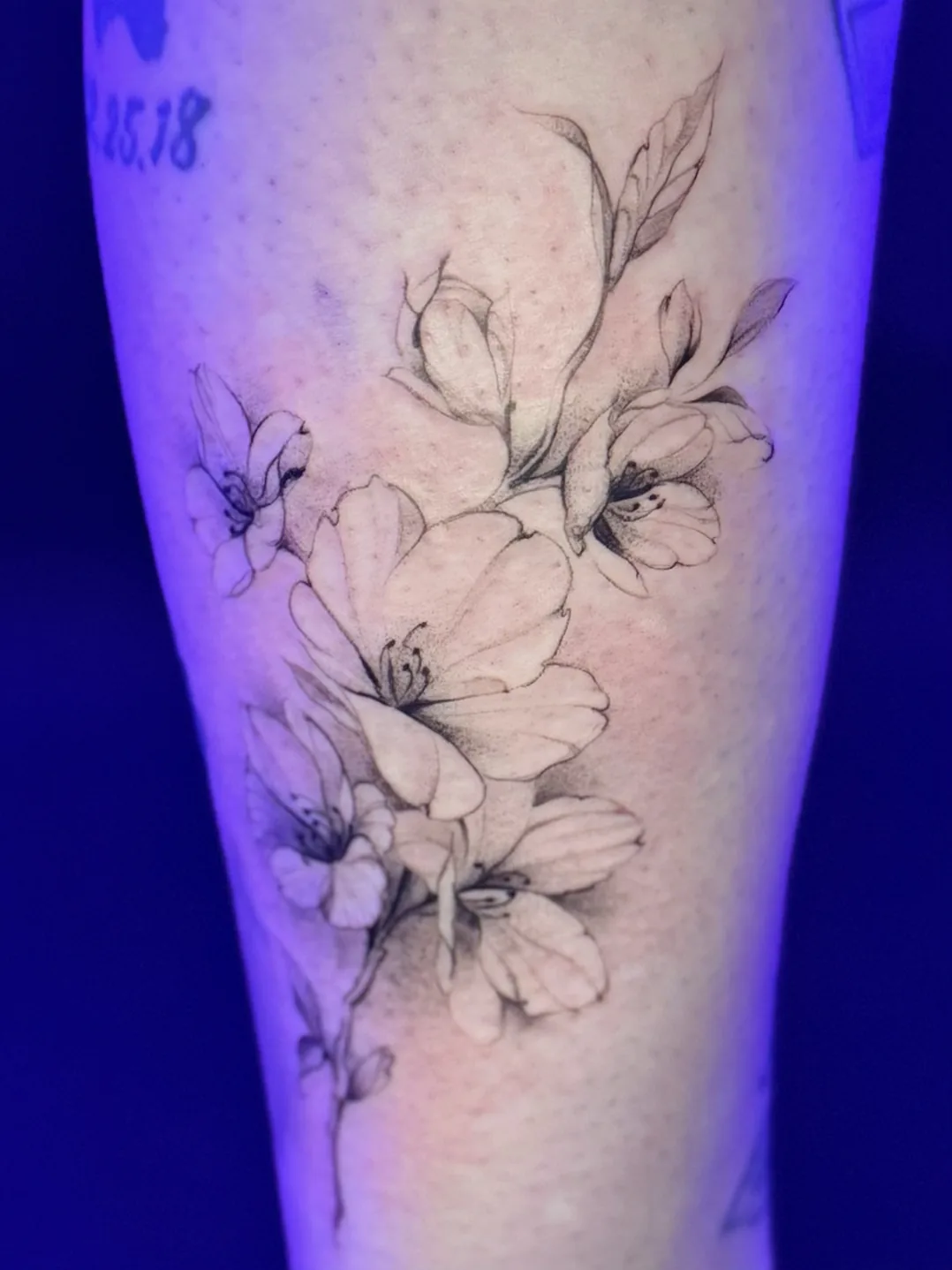 Fine line cherry blossom floral leg tattoo by Keisha Vo