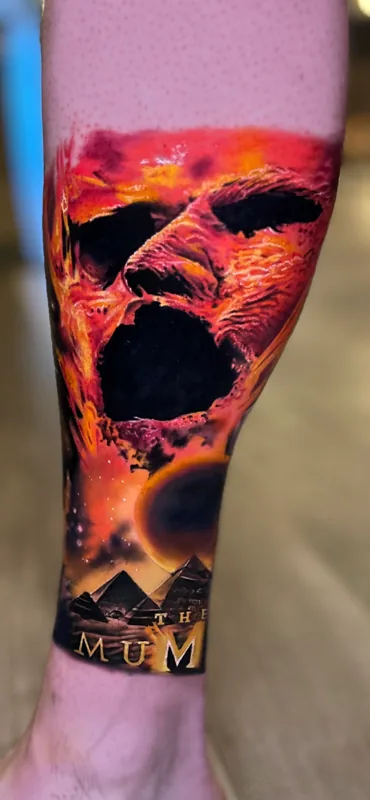 Color realism flaming skull and pyramids leg tattoo by Nate Cummings