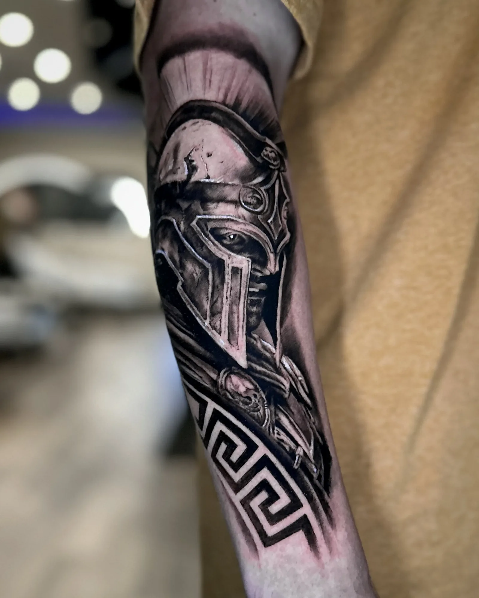 Black and grey Spartan warrior and Greek key forearm tattoo by Zach Truitt